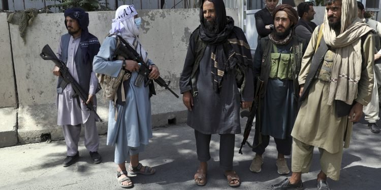 Taliban fighters stand guard at the main gate leading to the Afghan presidential palace, in Kabul, Afghanistan, Monday, Aug. 16, 2021. The U.S. military struggled to manage a chaotic evacuation from Afghanistan on Monday as the Taliban patrolled the capital and tried to project calm after toppling the Western-backed government. (AP Photo/Rahmat Gul)